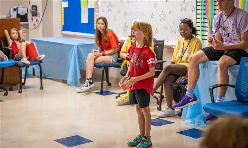 A boy acts in front of his group